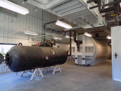 Engineering research facility with large cylindrical equipment inside an industrial workspace